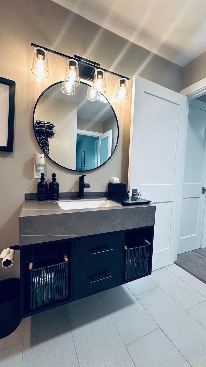 Clean bathroom vanity with a round mirror